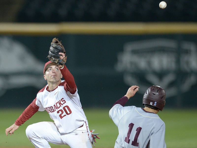 Arkansas second baseman Carson Shaddy misplays the late throw from the plate after a wild pitch allowed Louisiana-Monroe right fielder Johnny DeLaCruz to advance to second Tuesday, April 3, 2018, during the seventh inning at Baum Stadium in Fayetteville. 