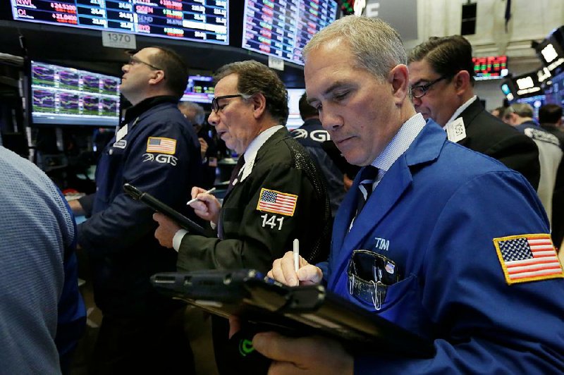 Timothy Nick (right) works with fellow traders on the floor of the New York Stock Exchange on Wednesday. Stocks opened sharply lower on Wall Street, but the markets recovered later in the day as fears of an escalating trade dispute between the U.S. and China ebbed. 
