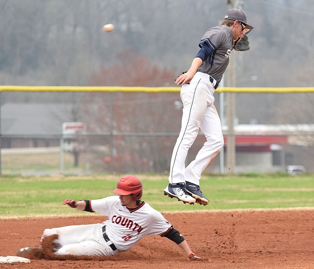 RICK PECK/SPECIAL TO MCDONALD COUNTY PRESS Shiloh Christian's shortstop Connor Clark leaps for a high throw while McDonald County's Caleb Curtis steals second base during the Mustangs' 4-3 win on March 26 at MCHS.