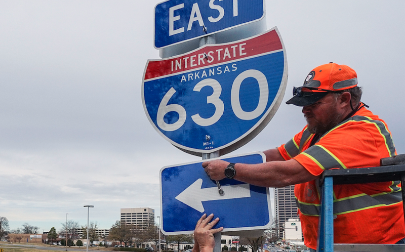 FILE — Workers install a sign along Interstate 630 in this December 2017 file photo.