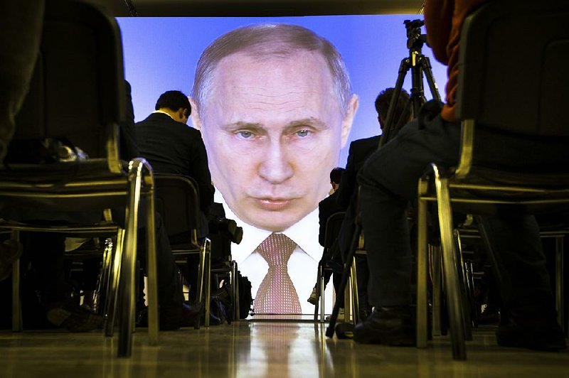 Journalists watch as Russian President Vladimir Putin gives his annual state of the nation address in Manezh on March 1, 2018, in Moscow, Russia.  