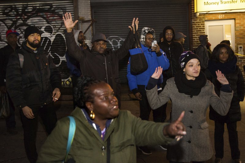 People react to the news after police officers shot and killed a man in the Crown Heights neighborhood of Brooklyn, Wednesday, April 4, 2018, in New York, while responding to reports of a man threatening people with a gun. (AP Photo/Kevin Hagen)