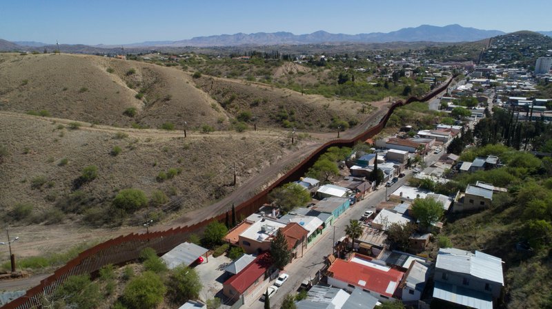 FILE - This April 2, 2017, file photo made with a drone, shows the U.S. Mexico border fence as it cuts through the two downtowns of Nogales. National guard contingents in U.S. states that border Mexico say they are waiting for guidance from Washington to determine what they will do following President Donald Trump's proclamation directing deployment to fight illegal immigration and drug smuggling. The National Guard in Texas said in a statement Thursday, April 5, 2018, said the deployment is in &quot;very early planning stages.&quot; (AP Photo/Brian Skoloff, File)