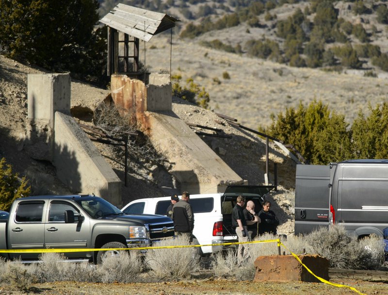 Law enforcement officials wait to load two bodies into a medical examiners truck after they were recovered from an abandoned mine in Utah's west desert near Eureka, Utah, Wednesday March 28, 2018. The two bodies found Wednesday in the abandoned mine are believed to be those of a teenage couple who disappeared months ago under suspicious circumstances, police said. (Steve Griffin/The Salt Lake Tribune via AP)