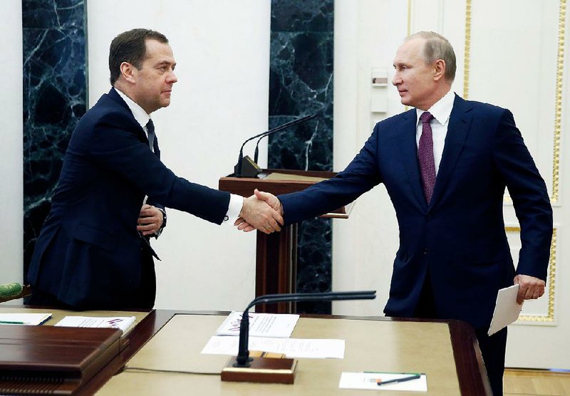 Russian President Vladimir Putin (right) greets Russian Prime Minister Dmitry Medvedev at a security council meeting Friday in Moscow. Russian officials said the new U.S. sanctions were “an unfriendly act” and vowed to respond with “comparable” harm. 