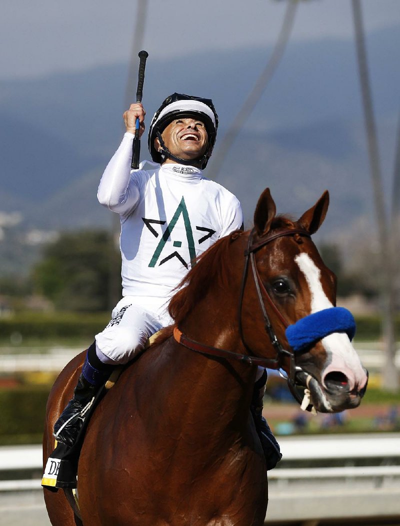 Mike Smith celebrates after riding Justify to victory in the Santa Anita Derby. The victory earned Justify a spot in the Kentucky Derby.  
