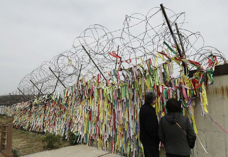 Visitors at the Imjingak pavilion in Paju, South Korea, look Saturday at ribbons that carry messages wishing for reunification and peace between North and South Korea.