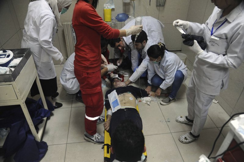 In this photo released by the Syrian official news agency SANA, shows a man receiving treatment at a hospital in Damascus, Syria, Saturday, April. 7, 2018. State TV said Army of Islam fighters pelted several neighborhoods in Damascus with mortar shells killing six civilians and wounding more than 30. (SANA via AP)