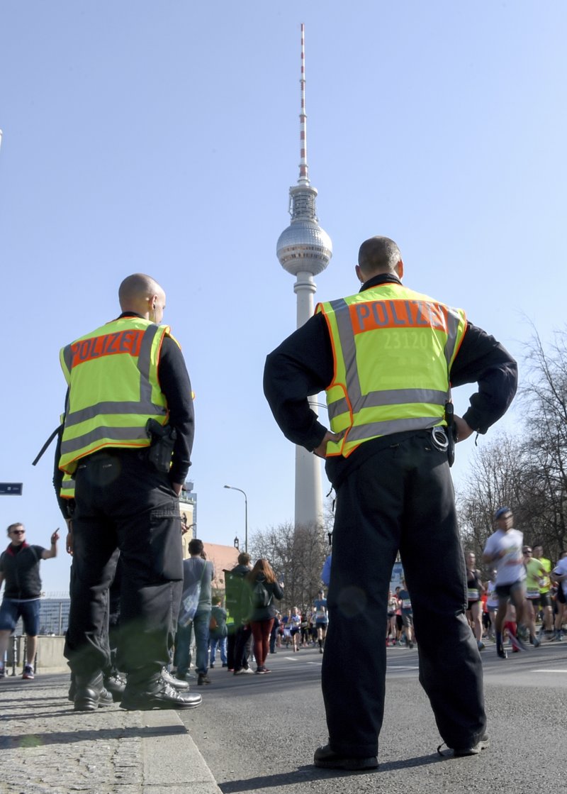Police guard during the half marathon run in Berlin, Sunday, April 8, 2018. The German daily Die Welt is reporting that police have foiled a knife attack on a half-marathon in Berlin. The paper says special police forces detained four men in connection with Sunday's sports event. They said the main suspect was planning to kill participants and spectators with knives. 