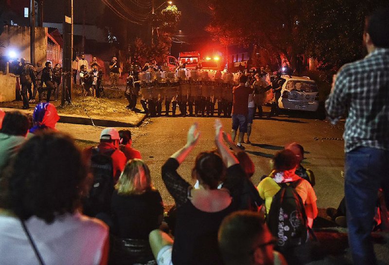Supporters of  Brazil’s former president, Luiz  Inacio Lula da Silva, protest his arrest Saturday near a line of police  outside the federal police department in Curitiba, Brazil.