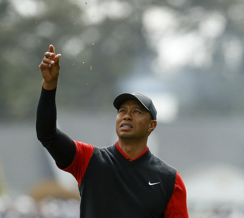 Tiger Woods tests the wind on the first hole during the fourth round at the Masters golf tournament Sunday, April 8, 2018, in Augusta, Ga. (AP Photo/Charlie Riedel)