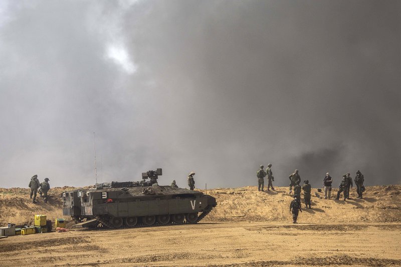 Israeli soldiers stand as smoke rises during demonstrations at the Israel Gaza border, Friday, April 6, 2018. Palestinians torched piles of tires near Gaza's border with Israel on Friday, sending huge plumes of black smoke into the air and drawing Israeli fire that killed two men in the second mass protest in the volatile area in a week. (AP Photo/Tsafrir Abayov)