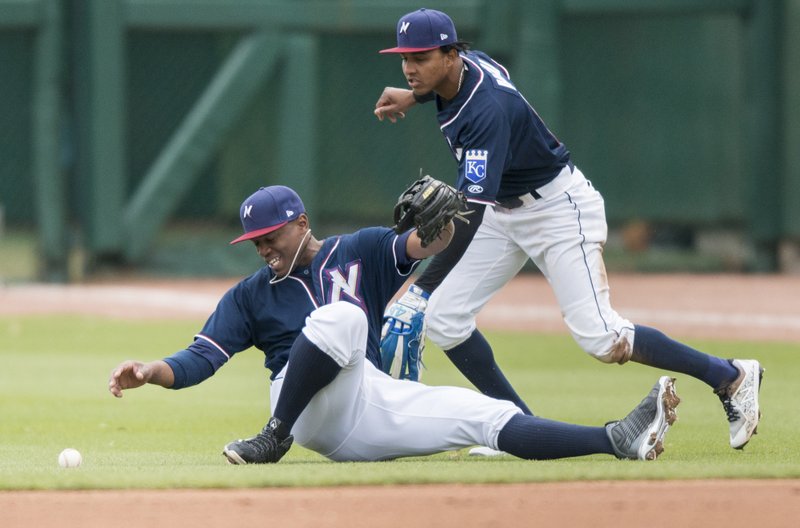 Northwest Arkansas Naturals right fielder Elier Hernandez (21) and shortstop Erick Mejia (9) reach for a ball Sunday at Arvest Ballpark in Springdale.