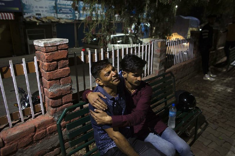 A father grieves for his son Monday outside a government hospital in Nurpur, India, after a school bus plunged off a mountain road in the Himalayan foothills.