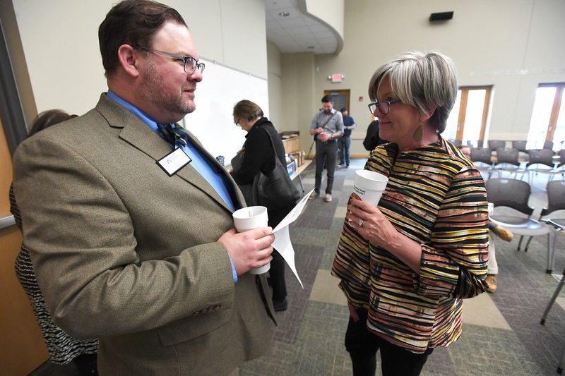 Lisa Cordes (right), director of artist services for Mid-America Arts Alliance, visits Monday with Patrick Ralston, director of the Arkansas Arts Council, at the Bentonville Public Library before an announcement about the Artist 360 program. The partnership between the Mid-America Arts Alliance and the Walton Family Foundation will provide grants to practicing artists in Northwest Arkansas.
