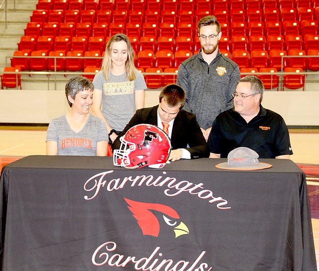 LYNN KUTTER ENTERPRISE-LEADER Farmington senior Caleb Williams signs a national letter of intent to play football and run track for Hendrix College of Conway. Caleb's family (from left): Melisa Williams (mother), Rebekah Williams (sister), Caleb, Josh Williams (brother), and Paul Williams (father) cheer him on.