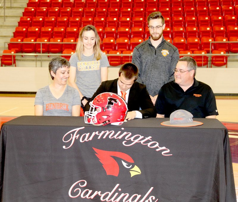 LYNN KUTTER ENTERPRISE-LEADER Farmington senior Caleb Williams signs a national letter of intent to play football and run track for Hendrix College of Conway. Caleb's family (from left): Melisa Williams (mother), Rebekah Williams (sister), Caleb, Josh Williams (brother), and Paul Williams (father) cheer him on.