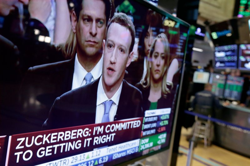Facebook CEO Mark Zuckerberg appears on a television screen on the floor of the New York Stock Exchange as he testifies in the Senate in Washington, Tuesday, April 10, 2018. (AP Photo/Richard Drew)