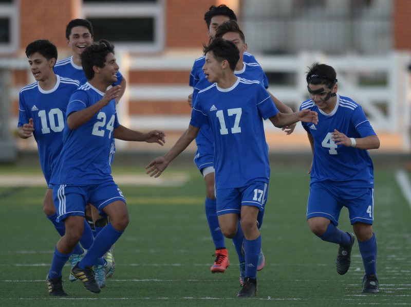 NWA Democrat-Gazette/ANDY SHUPE Rogers junior Brayan Flores (17) celebrates Tuesday, April 10, 2018, with teammates Johan Rodriguez (24) and Rony Flores after scoring the game-winning goal during the second half against Springdale at Jarrell Williams Bulldog Stadium in Springdale. Visit nwadg.com/photos to see more photographs from the match.