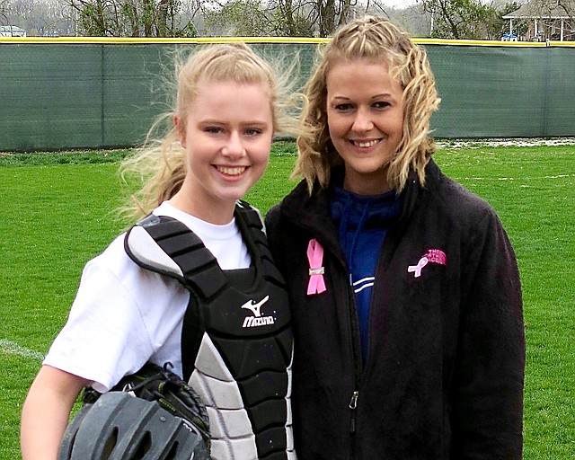 Taylor Norman (left) stands with her mother, Kristin Ferguson, on Tuesday, April 3, at Reynolds Memorial Complex in Gentry. Gentry played Greenland in a high school softball game dubbed "No One Fights Alone" to bring more awareness to breast cancer. The players, coaches and managers of each team dedicated the game in honor of, or in memory of, someone who has battled breast cancer. Both teams wore special jerseys during the game. Ferguson is a breast cancer survivor and threw out a ceremonial first pitch to her daughter before the start of the game.