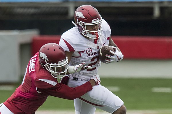Arkansas running back Devwah Whaley tries to run through a tackle attempt of safety Santos Ramirez during the Razorbacks' spring game Saturday, April 7, 2018, in Little Rock. 