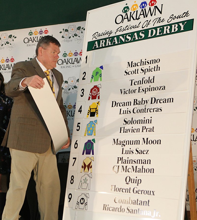 The Sentinel-Record/Richard Rasmussen DERBY HOPEFULS: Oaklawn General Manager Wayne Smith places the name of the number 1 horse Beautiful Shot onto the board during the annual Arkansas Derby Draw Wednesday. The 82nd running of the Arkansas Derby is set for a 6:18 post time on Saturday.