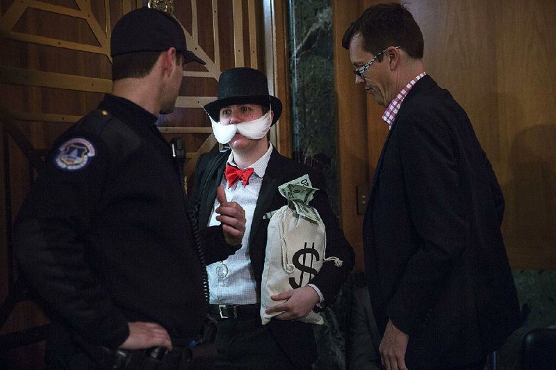 An attendee dressed as the “Monopoly Man” leaves a Senate banking committee hearing, where White House budget office chief Mick Mulvaney testified in his role as acting director of the Consumer Financial Protection Bureau.  