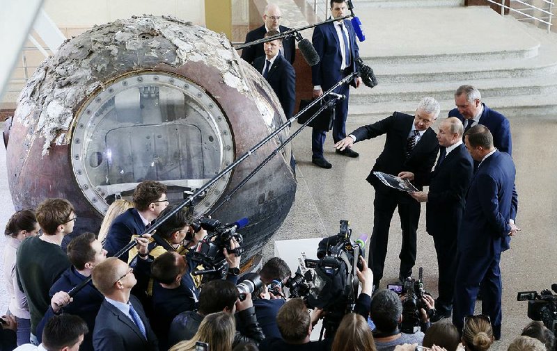 Russian President Vladimir Putin (center) is given a tour Thursday of the space pavilion at a Moscow exhibit on national economic achievements.