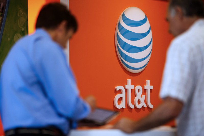 Sales staff help customers at the AT&T Retail Store in Manhattan Beach, California, on July 22, 2013. 