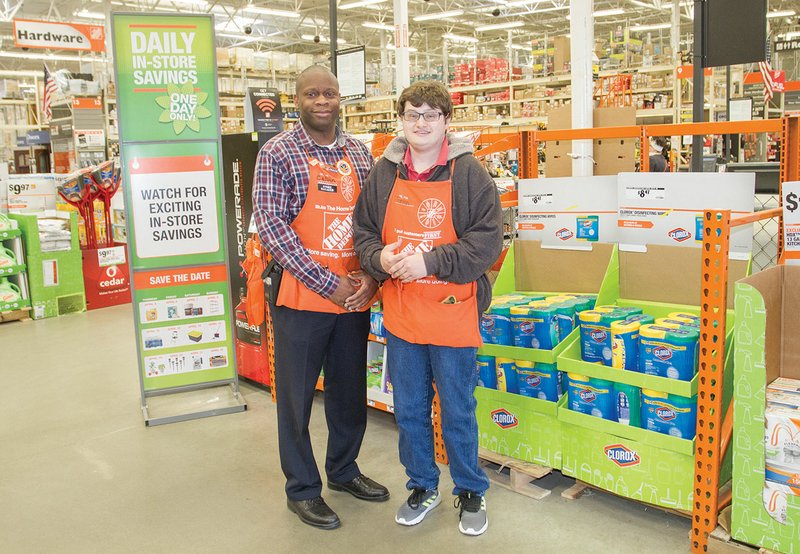 Batesville Home Depot store manager Calvin Wright, left, stands with Jordan Branscum, an employee who was named one of 18 Famous Arkansans earlier this month. Branscum, who has cerebral palsy, received the honor from the Arkansas Governor’s Office and the state Department of Human Services Division of Developmental Disabilities Services. Wright also presented Branscum with a Home Depot Homer Award for “for exemplifying the core values of Home Depot.”