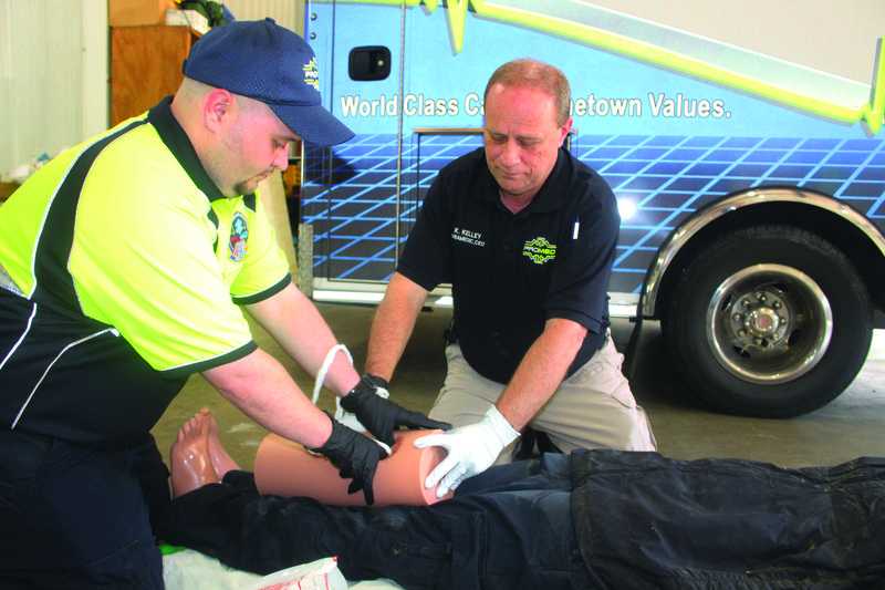 Packing: Left, Trey Johnson, ProMed paramedic and Ken Kelley, ProMed CEO, demonstrates “wound packing” on a training dummy during a Stop the Bleed training session. Kaitlyn Rigdon/News-Times