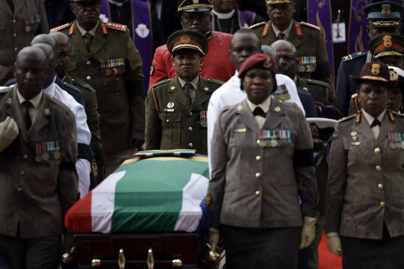 A military honor guard carries anti-apartheid activist Winnie Madikizela-Mandela's coffin, wrapped in the flag of South Africa, out of Orlando stadium following her funeral service, in Soweto, South Africa, Saturday, April 14, 2018. Tens of thousands of people sang, cheered and cried as the flag-draped casket of anti-apartheid activist Winnie Madikizela-Mandela was escorted from her official funeral on Saturday, after supporters defended her complex legacy with poetry and anger. (AP Photo/Jerome Delay)