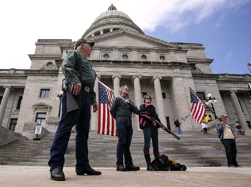 Second Amendment supporters (from left) Ed Matowitz, Gary Nicholson and Jackie Fortin listen to speakers at Saturday’s rally outside the state Capitol. 