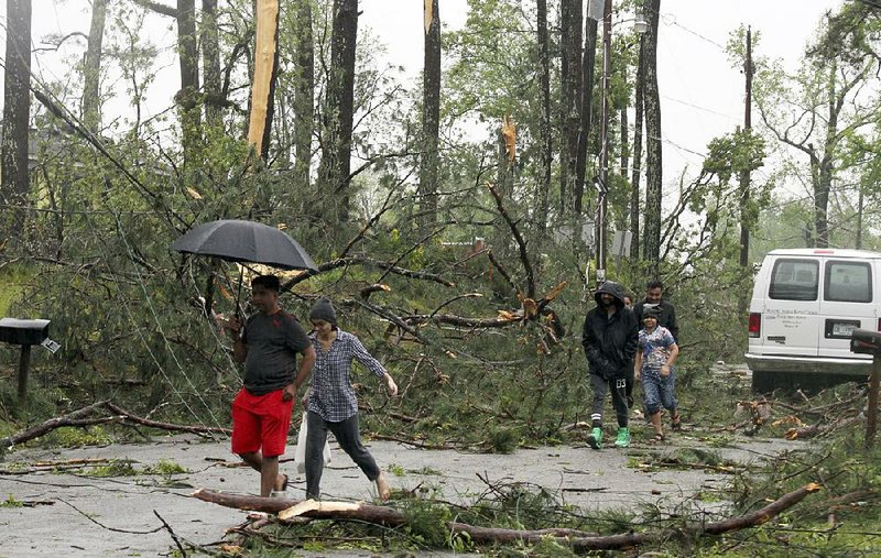 Residents in Meridian, Miss., survey the damage Saturday after a storm system moved through, downing power lines and felling trees.  