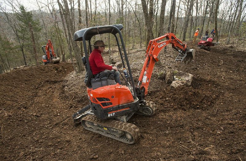 Bret Deutscher with Rock Solid Trail Contracting works on a section of trail at Lake Leatherwood Park in Eureka Springs. Construction costs for six new downhill trails is expected to run almost $1 million.  