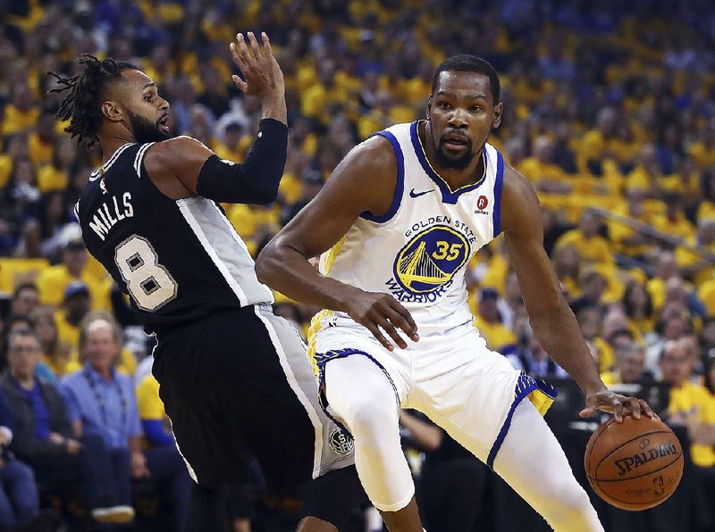 Golden State forward Kevin Durant drives to the basket against San Antonio’s Patty Mills on Saturday during the Warriors’ 113-92 victory over the Spurs in Game 1 of their NBA Western Conference playoff series. Durant led the Warriors with 24 points, 8 rebounds and 7 assists.