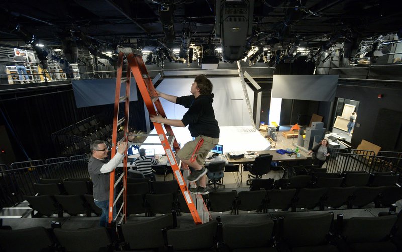 NWA Democrat-Gazette/ANDY SHUPE Michael Riha, left, chairman of the University of Arkansas Theatre Department, steadies a ladder for Austin Aschbrenner, a first-year scenic design graduate student from Beebe, as they focus lights April 6 inside the renovated Global Campus Theatre on the Fayetteville square.