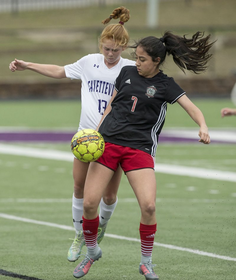 Jessica Paez (7) of Springdale and Morganne Browning (13) of Fayetteville compete for the ball Friday, April 6, 2018, during the match at Fayetteville's Harmon Stadium.