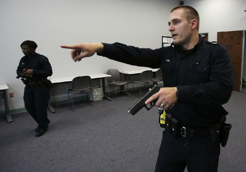 Little Rock police cadets Cameron Vail (right) and Eboney Warren run a simulation of an investigation on Friday at the Little Rock Police Training Academy. The department reported a decrease in the number of use-of-force incidents last year.

