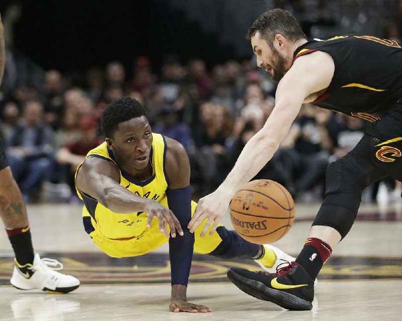 Indiana Pacers guard Victor Oladipo (left) passes as Cleveland Cavaliers center Kevin Love defends in the second half of Game 1 of Sunday’s NBA Eastern Conference fi rst-round series in Cleveland. Oladipo finished with 32 points, 6 rebounds, 4 assists and 4 steals to power the Pacers to a 98-80 victory.