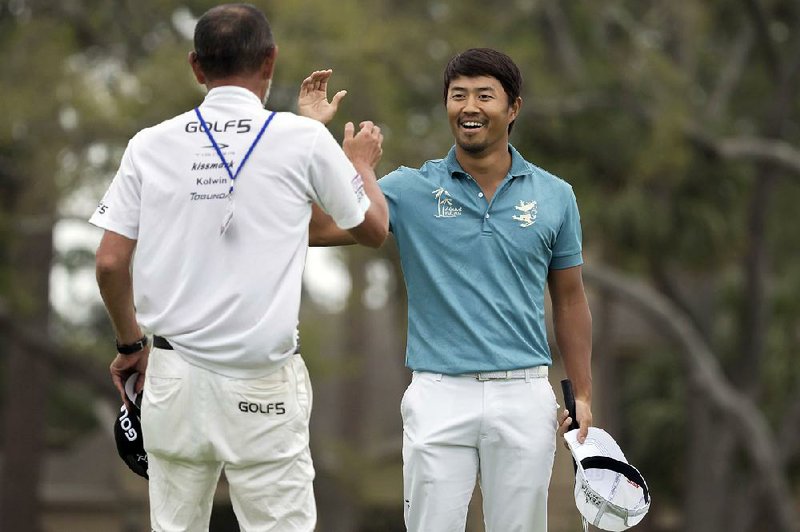 Satoshi Kodaira of Japan celebrates a birdie putt on the 17th green with his caddie Masanoki Omizo of Japan during a three hole playoff against Si Woo Kim of South Korea during the final round of the RBC Heritage golf tournament in Hilton Head Island, S.C., Sunday, April 15, 2018. 
