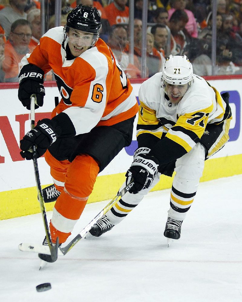 Travis Sandheim of the Philadelphia Flyers (left) is chased by Evgeni Malkin of the Pittsburgh Penguins behind the Flyers’ net during the Penguins’ 5-1 victory on Sunday in Philadelphia.