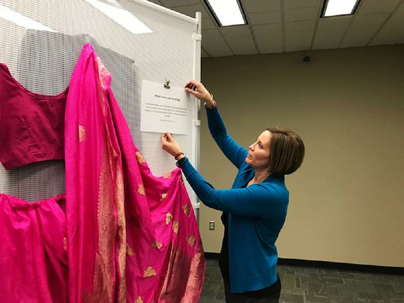 Allison Vetter, Henderson State University’s Title IX coordinator, is shown with a sari in an exhibition about clothes that sexual-assault victims wore.