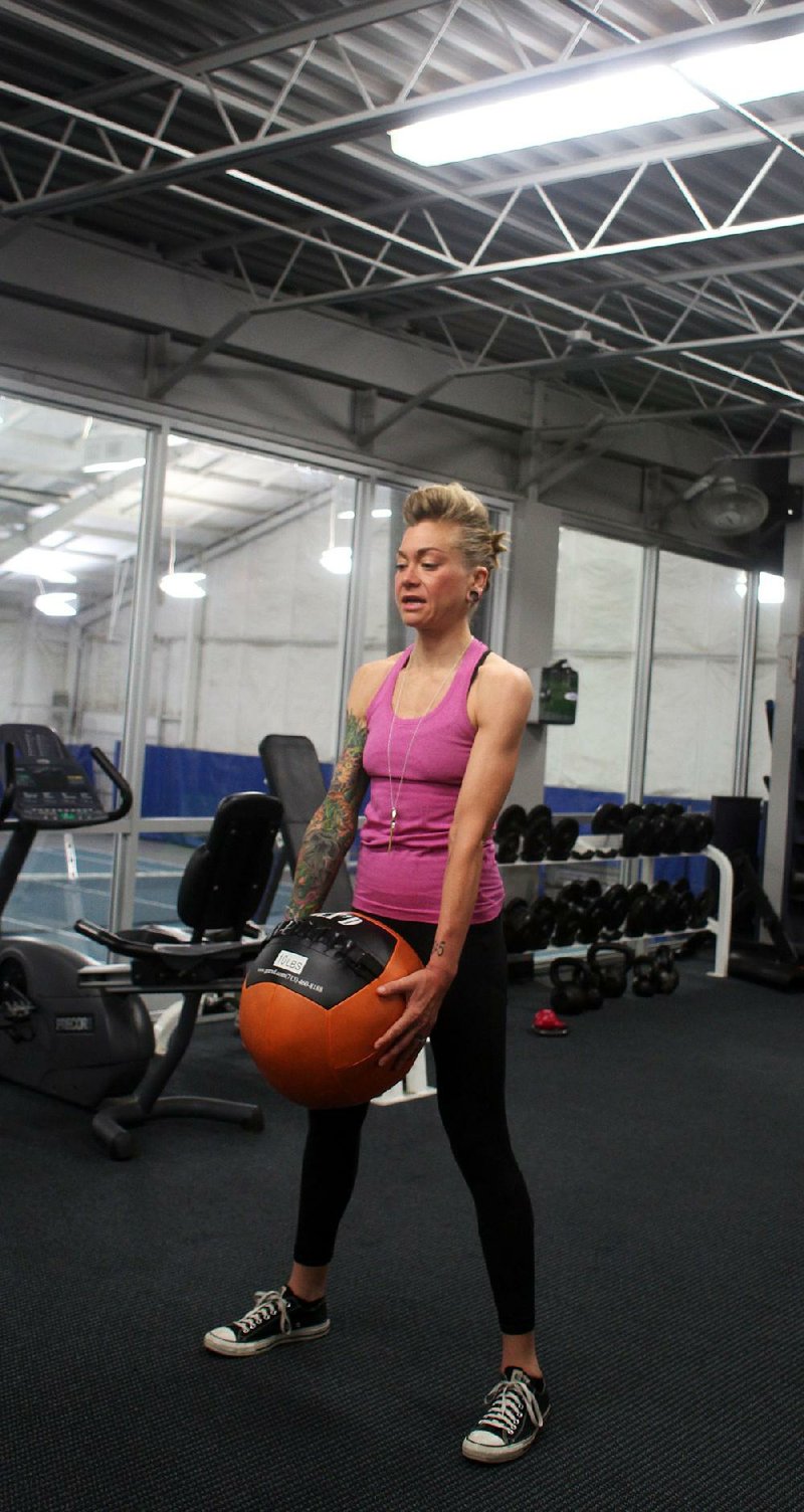 Fitness instructor Lindsay Petruk does step 1 of the Medicine Ball Power Toss 