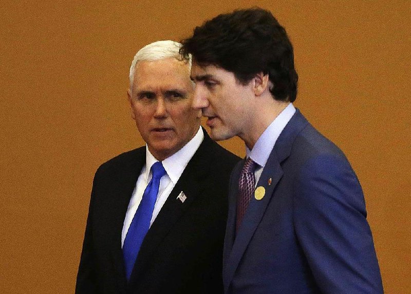 Vice President Mike Pence (left) and Canadian Prime Minister Justin Trudeau confer Saturday at the Summit of the Americas in Peru. 