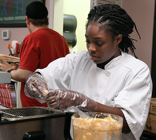 The Sentinel-Record/Grace Brown - Arkansas Career Training Institute culinary arts student, Minesha Kabba, prepares fired plantanes during Friday Falvors at ACTI on Friday, April 13, 2018.