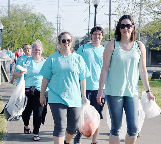 The Sentinel-Record/Grace Brown - Maggie Hardage, left, and Sandra Davis lead a slew of people walking down the Hot Springs Creek Greenway Trail with trash bags during the inagural Trash Bag Walk sponsored by Ouachita Childrens Center on Thursday, April 12, 2018.