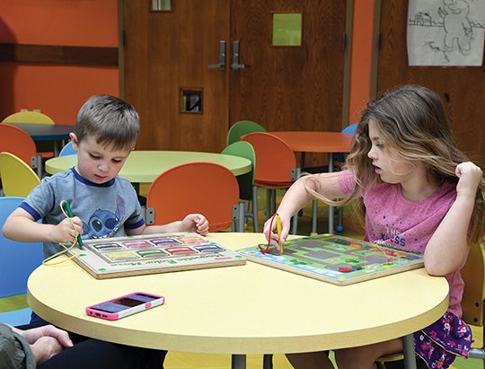 The Sentinel-Record/Grace Brown - Noah Gauldin, 3, and his sister, Amelia, enjoy magnetic mazes in the children's section of the Garland County Library on Tuesday, March 10, 2018. 