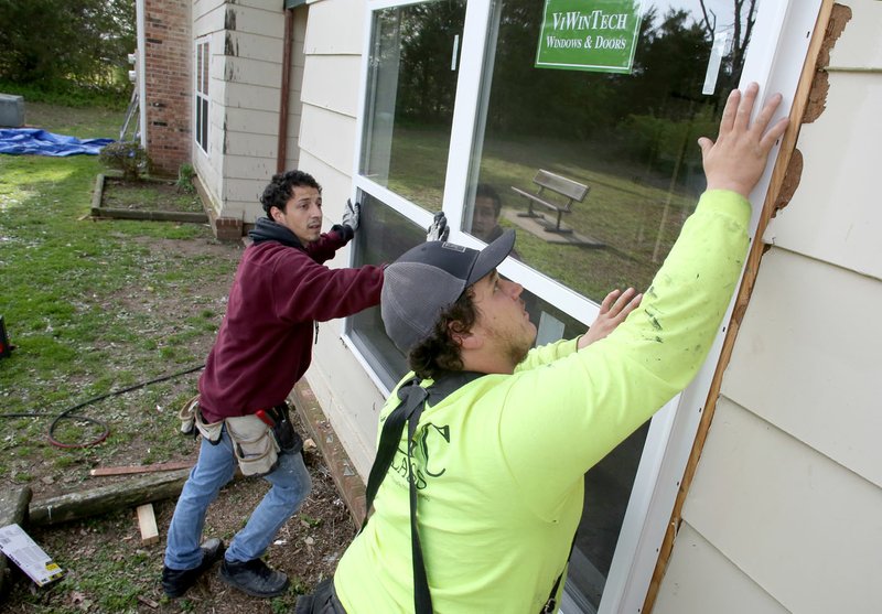 Dakota Hays (right) and Levi Balentine, both with Contractors Inc., replace a window Wednesday in one of the apartment units at the Southmont Apartments on Curtis Avenue in Fayetteville. Emet Capital Management out of New York bought the complex in December and has begun a multimillion-dollar renovation campaign under the new name Highpoint Apartments that should wrap by the end of the year.