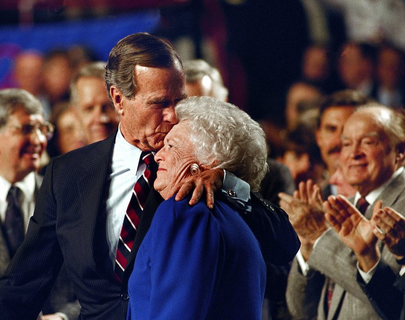 In this Nov. 2, 1992, file photo, entertainer Bob Hope, back right, applauds as President George H. W. Bush kisses his wife Barbara during a pre-election rally at the Astro Arena in Houston. Former first couple George and Barbara Bush's relationship is a true love story, described by granddaughter Jenna Bush Hager as "remarkable." They met at a Christmas dance. She was 17. He was 18. Two years later they were married. Now 73 years later, with Barbara Bush declining further medical care for health problems, they are the longest-married couple in presidential history. (AP Photo/Ron Edmonds/File)
